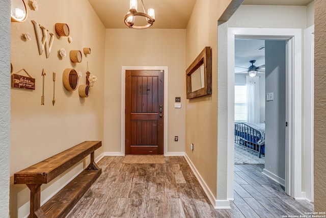 12177 Tower Frst, San Antonio, TX 78253 - doorway featuring baseboards, wood finished floors, and ceiling fan with notable chandelier