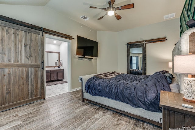 12177 Tower Frst, San Antonio, TX 78253 - bedroom with a barn door, wood finished floors, visible vents, and ensuite bath