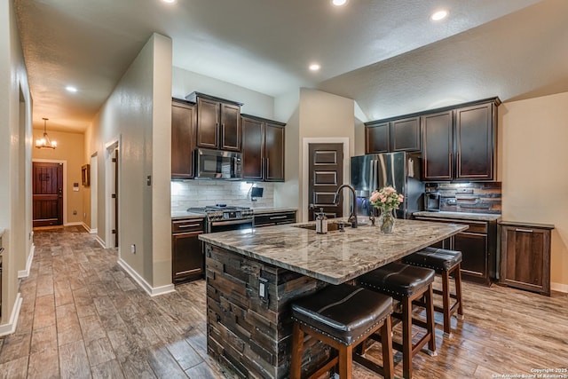 12177 Tower Frst, San Antonio, TX 78253 - kitchen featuring a kitchen breakfast bar, light stone counters, a sink, dark brown cabinetry, and appliances with stainless steel finishes
