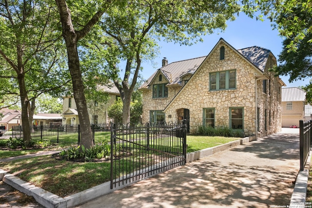 204 Parklane, Olmos Park, TX 78212 - tudor home with stone siding, a chimney, a standing seam roof, and metal roof