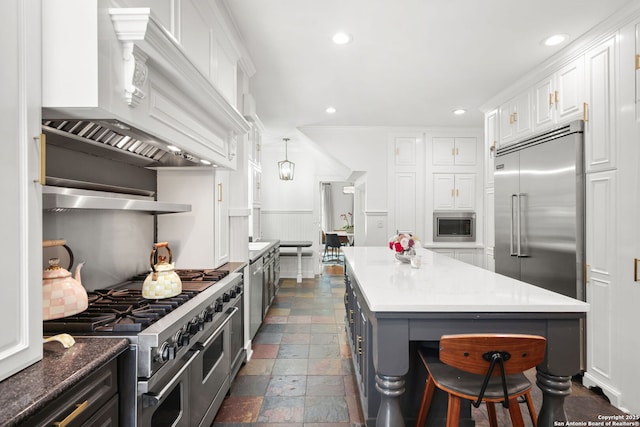 204 Parklane, Olmos Park, TX 78212 - kitchen with built in appliances, stone tile flooring, white cabinetry, recessed lighting, and a center island