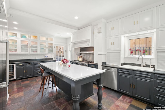 204 Parklane, Olmos Park, TX 78212 - kitchen with dishwasher, a sink, a kitchen bar, white cabinetry, and decorative backsplash