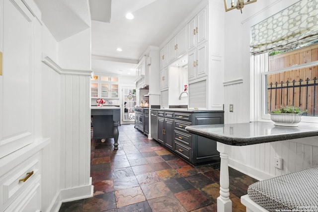 204 Parklane, Olmos Park, TX 78212 - kitchen with white cabinets, a decorative wall, stone tile floors, recessed lighting, and dark countertops