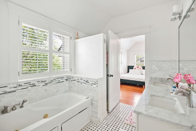 204 Parklane, Olmos Park, TX 78212 - ensuite bathroom with vaulted ceiling, a jetted tub, double vanity, and tile walls