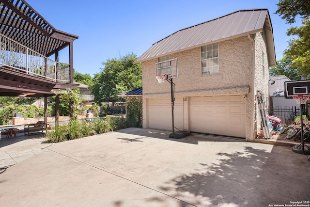 204 Parklane, Olmos Park, TX 78212 - view of property exterior featuring a standing seam roof, an attached garage, stucco siding, metal roof, and driveway