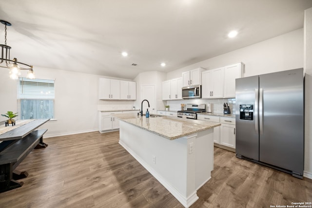 kitchen featuring backsplash, white cabinets, appliances with stainless steel finishes, and a sink