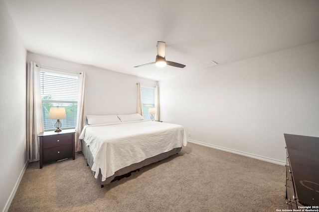 bedroom featuring light colored carpet, baseboards, and multiple windows