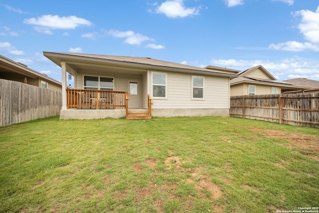 back of house with a fenced backyard and a yard