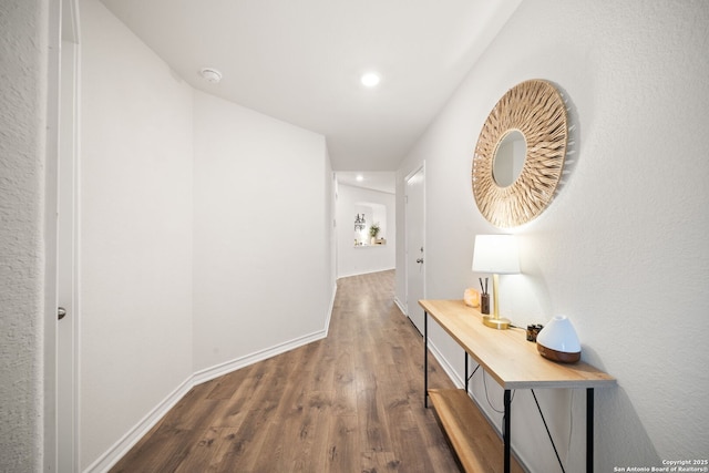 hall featuring baseboards, dark wood-style floors, and recessed lighting