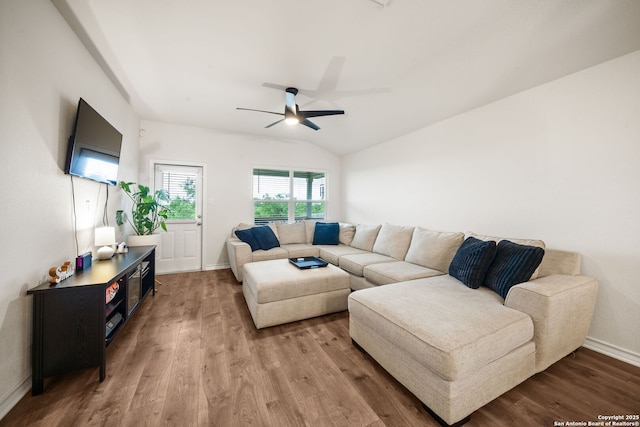 living area featuring baseboards, vaulted ceiling, wood finished floors, and ceiling fan