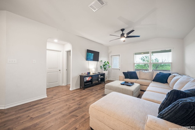 living room featuring wood finished floors, ceiling fan, arched walkways, baseboards, and visible vents