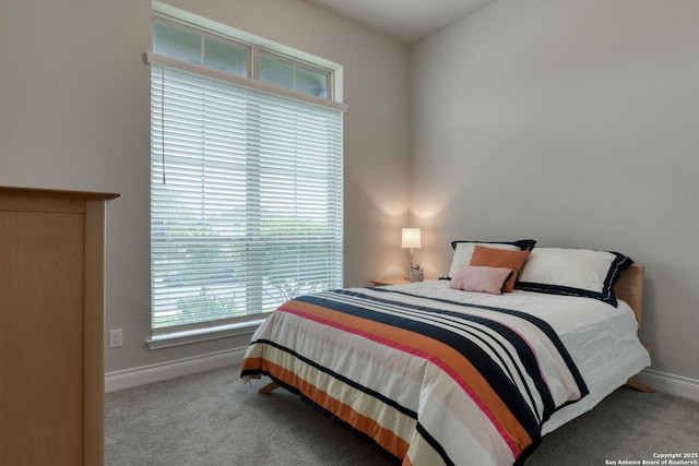 carpeted bedroom featuring baseboards and multiple windows