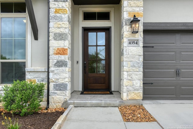 doorway to property with stucco siding and stone siding