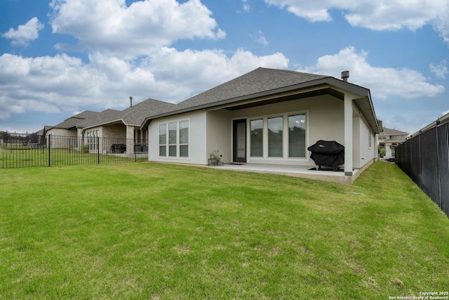 back of house featuring a yard, roof with shingles, a patio, and a fenced backyard