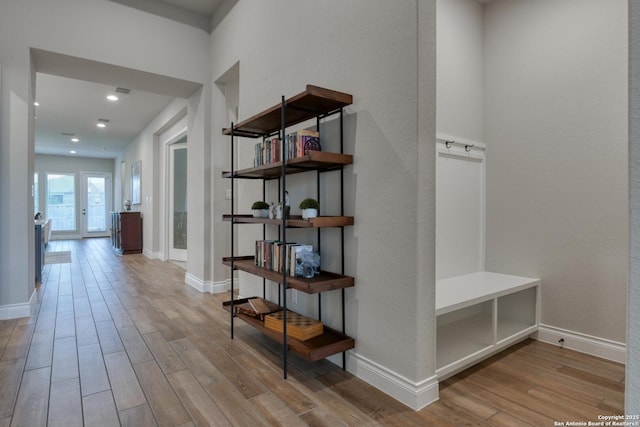 corridor featuring baseboards, wood finished floors, and recessed lighting