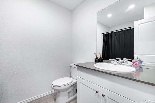 6057 Companion Loop, Bulverde, TX 78163 - bathroom featuring toilet, baseboards, wood finished floors, a textured wall, and vanity