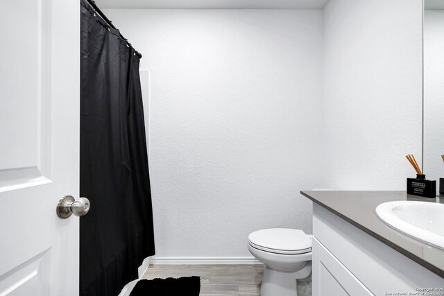 6057 Companion Loop, Bulverde, TX 78163 - full bath featuring baseboards, wood finished floors, vanity, and toilet