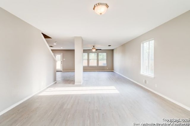unfurnished living room featuring a ceiling fan, wood finished floors, and baseboards