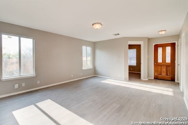 interior space with visible vents, wood finished floors, and baseboards