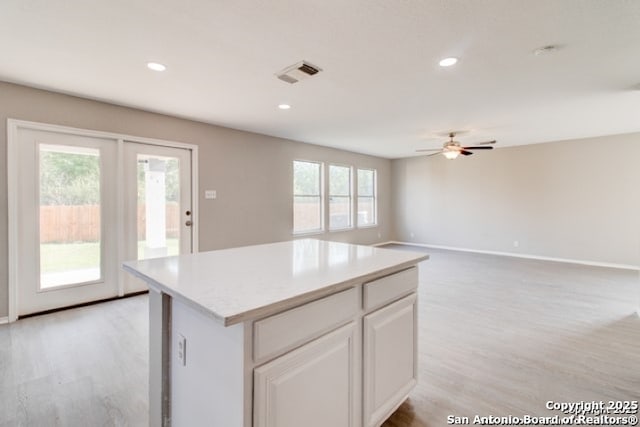 kitchen with visible vents, a ceiling fan, light wood finished floors, and light countertops