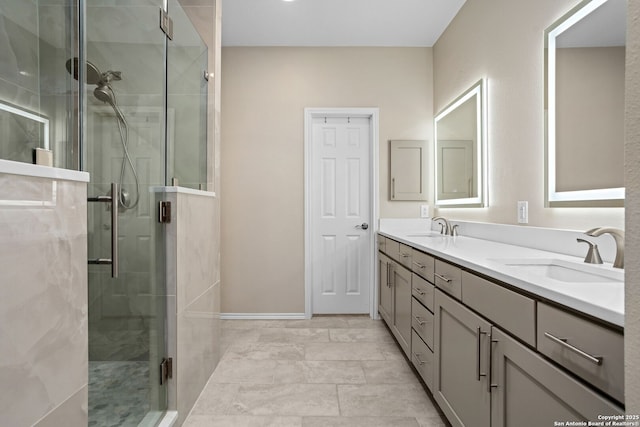 full bathroom with double vanity, a shower stall, and a sink