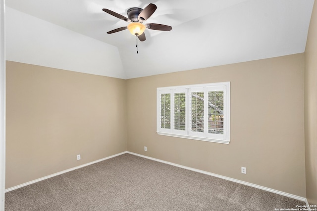 carpeted spare room with a ceiling fan, vaulted ceiling, and baseboards
