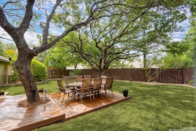 view of yard featuring a fenced backyard, a wooden deck, and outdoor dining area