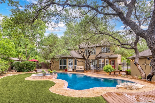 view of swimming pool with a deck, an outdoor living space, a yard, fence, and a pool with connected hot tub