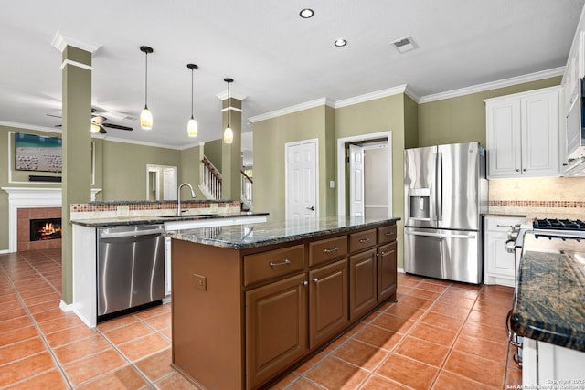 kitchen with a sink, stainless steel appliances, a center island, a ceiling fan, and visible vents