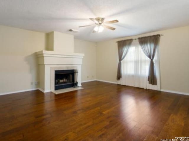 6635 Meadow Dawn, Converse, TX 78109 - unfurnished living room with baseboards, wood finished floors, ceiling fan, and a fireplace with flush hearth