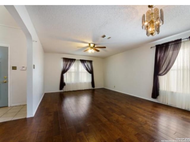 6635 Meadow Dawn, Converse, TX 78109 - unfurnished room with hardwood / wood-style floors, arched walkways, ceiling fan with notable chandelier, and a textured ceiling
