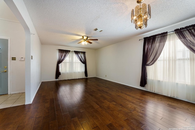 6635 Meadow Dawn, Converse, TX 78109 - empty room with wood-type flooring, visible vents, a textured ceiling, arched walkways, and ceiling fan with notable chandelier