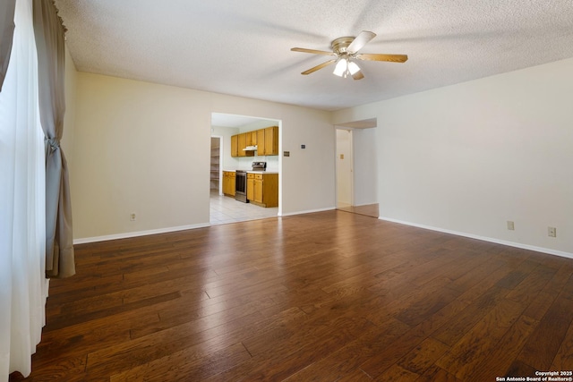 6635 Meadow Dawn, Converse, TX 78109 - unfurnished living room featuring light wood finished floors, a ceiling fan, a textured ceiling, and baseboards