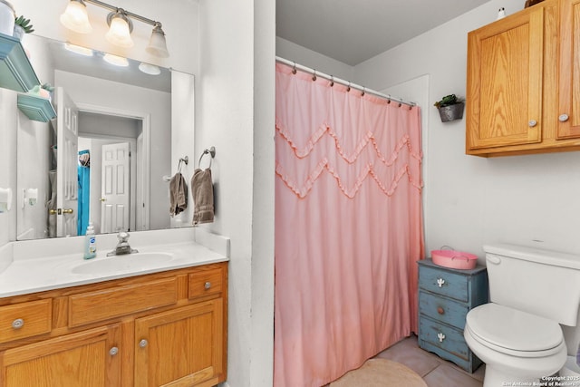bathroom with curtained shower, vanity, toilet, and tile patterned flooring