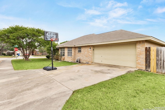 view of side of home featuring a yard, brick siding, fence, a garage, and driveway