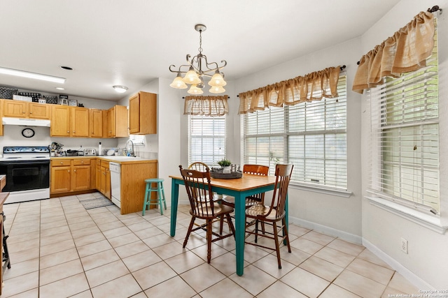 dining area featuring a chandelier, baseboards, and light tile patterned flooring
