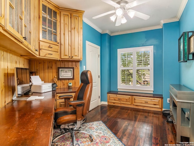 home office featuring dark wood-style flooring, wooden walls, a ceiling fan, and ornamental molding