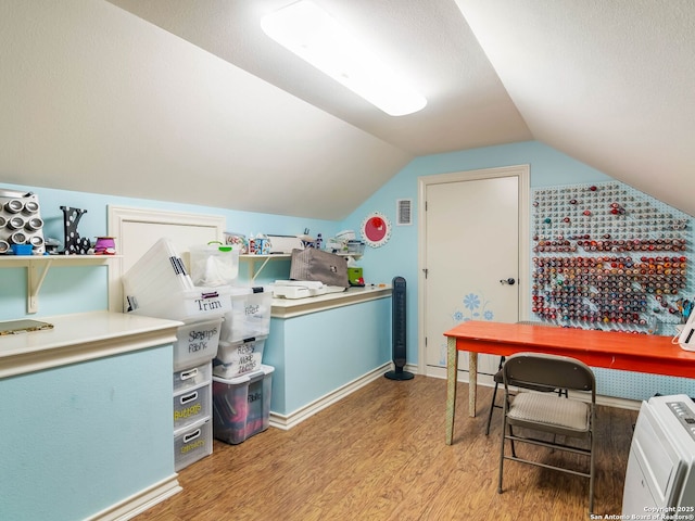 office space featuring visible vents, wood finished floors, and vaulted ceiling