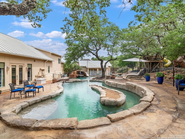 view of pool with a patio area, an outdoor structure, a fenced in pool, french doors, and fence