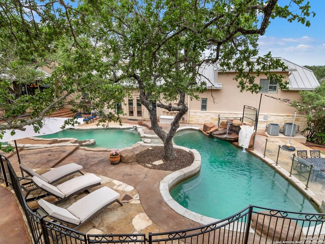 pool with french doors and a patio area