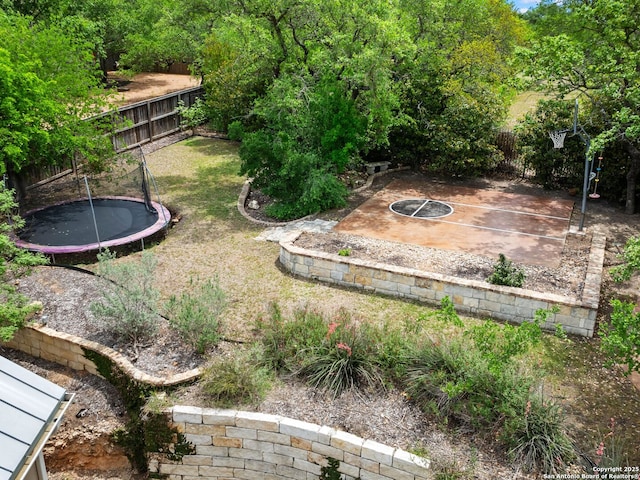 view of yard featuring a trampoline and a fenced backyard