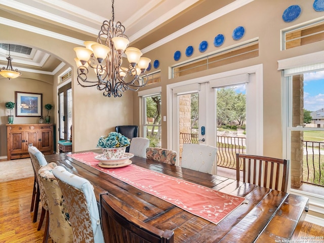 dining space featuring arched walkways, french doors, and light wood finished floors