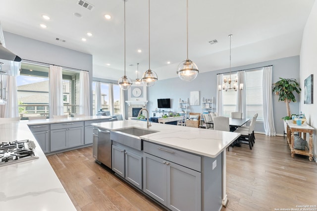 kitchen featuring a sink, plenty of natural light, gray cabinets, and visible vents