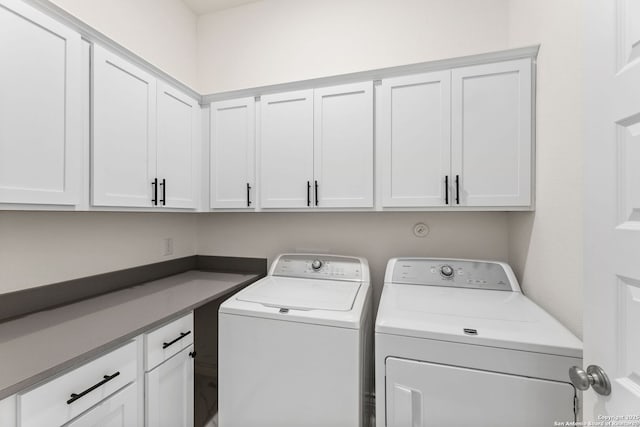 washroom featuring washer and clothes dryer and cabinet space