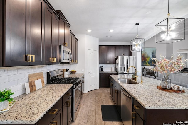kitchen featuring tasteful backsplash, dark brown cabinetry, stainless steel appliances, a sink, and a notable chandelier