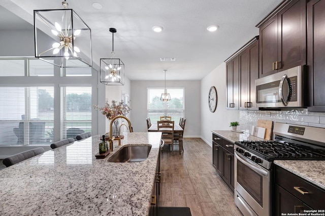 kitchen with recessed lighting, a sink, an inviting chandelier, stainless steel appliances, and visible vents