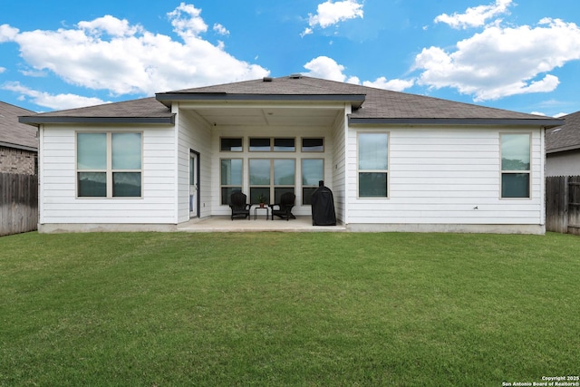 rear view of property featuring a patio, a yard, and a fenced backyard