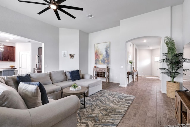 living area with recessed lighting, ceiling fan, visible vents, arched walkways, and wood finished floors
