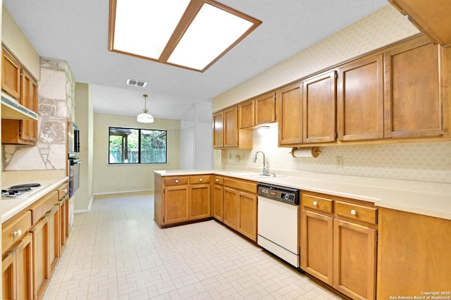 kitchen featuring a sink, visible vents, baseboards, white appliances, and a peninsula