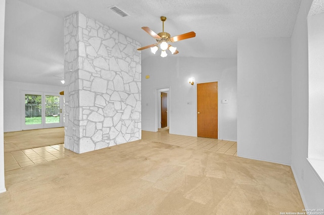 carpeted empty room featuring a ceiling fan, visible vents, a textured ceiling, tile patterned flooring, and lofted ceiling